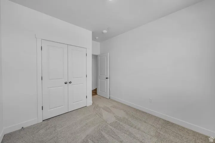 Unfurnished bedroom featuring carpet and a closet