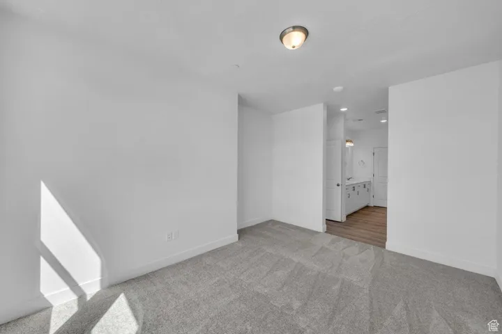 Carpeted spare room with baseboards