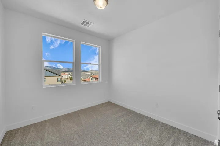 Empty room featuring carpet flooring and baseboards