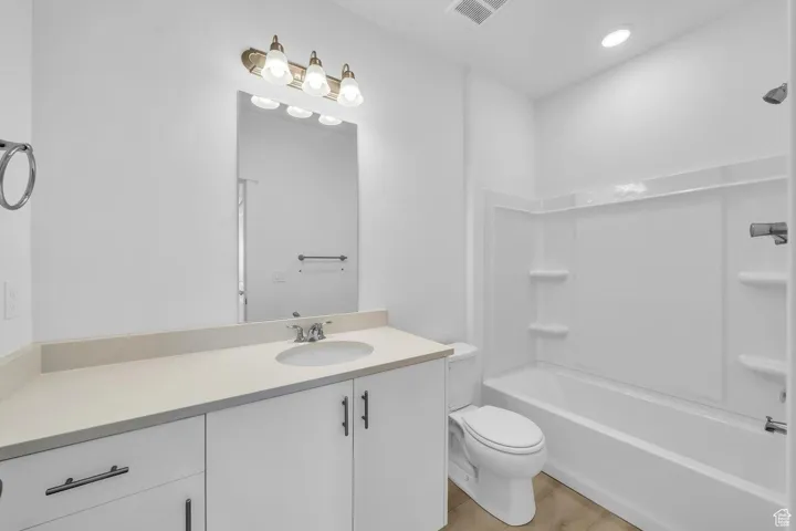 Full bathroom featuring vanity, shower / washtub combination, and wood finished floors
