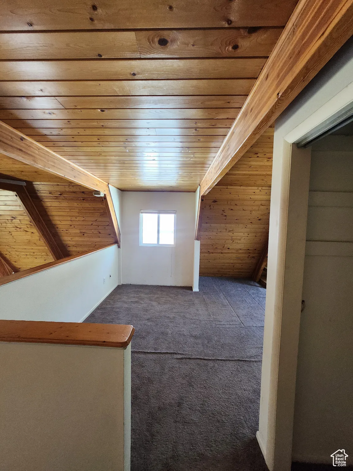 Bonus room with wooden ceiling and dark carpet