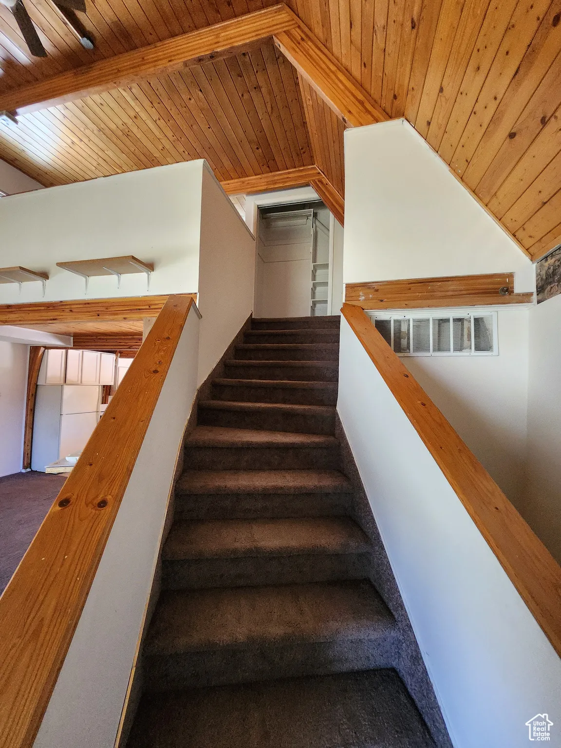 Staircase with wooden ceiling and lofted ceiling