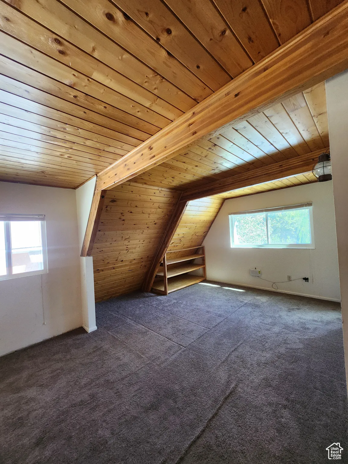Additional living space featuring wood ceiling, dark colored carpet, and vaulted ceiling