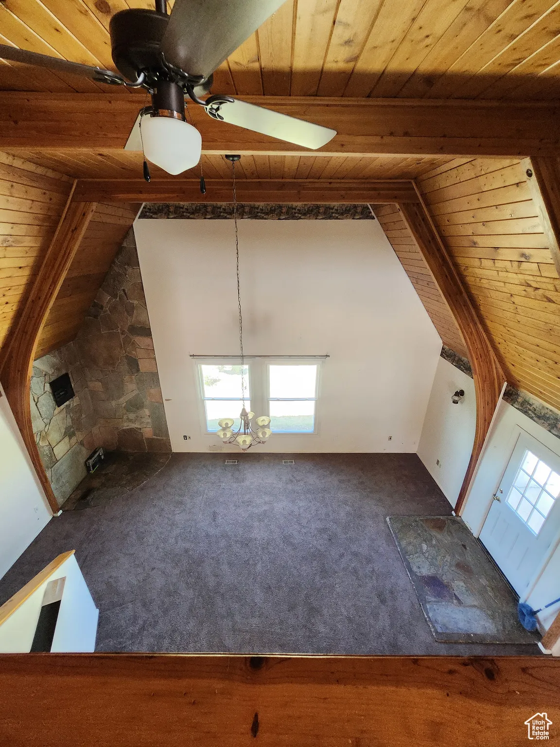 Unfurnished living room with a wood ceiling with exposed beams, carpet flooring, high vaulted ceiling, and ceiling fan