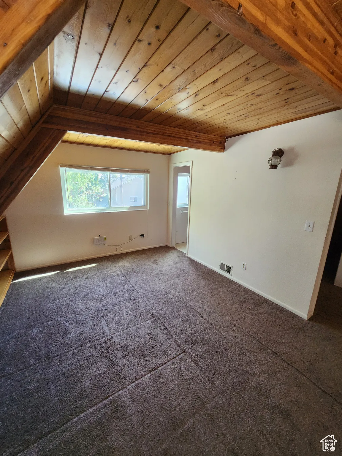 Additional living space with wooden ceiling and carpet flooring