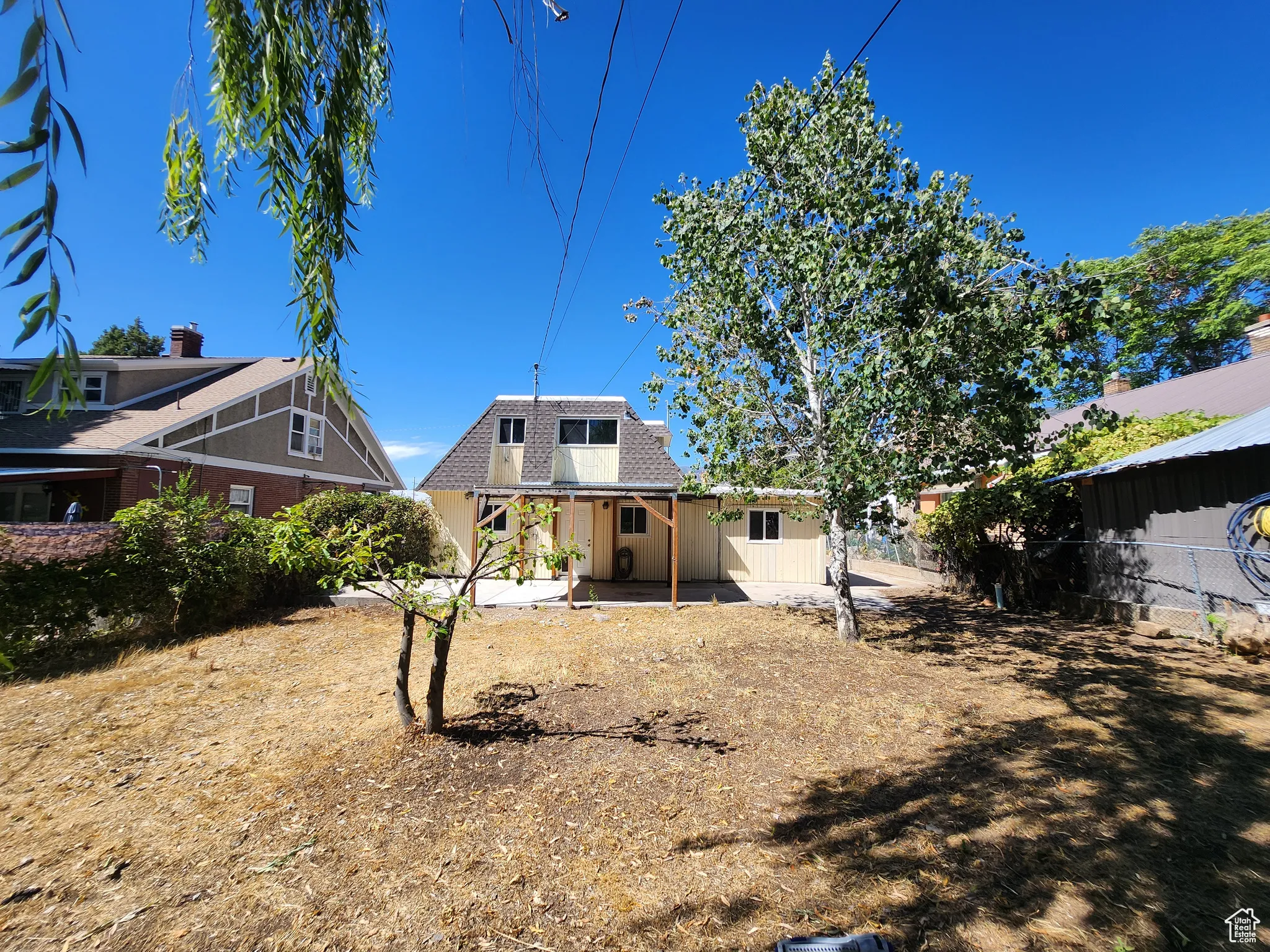 Rear view of house with mansard roof and roof with shingles