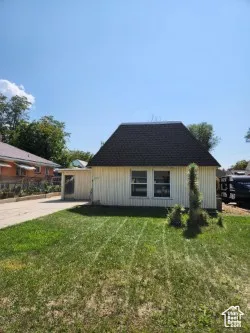 View of home's exterior featuring a yard and a shingled roof