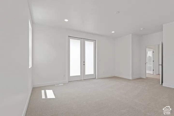 Spare room with light colored carpet, french doors, and recessed lighting