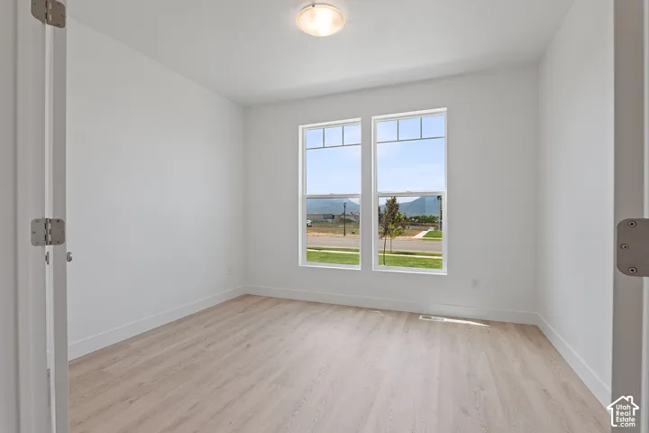 Empty room featuring light wood-type flooring and a mountain view