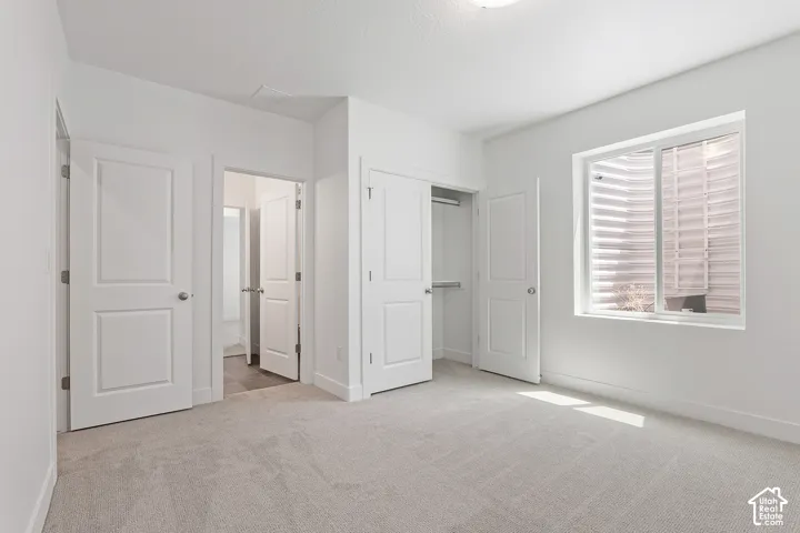 Unfurnished bedroom with carpet flooring, a closet, and connected bathroom