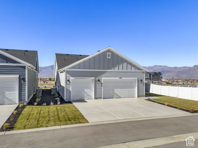 View of front of home with board and batten siding, a mountain view, driveway, and a garage