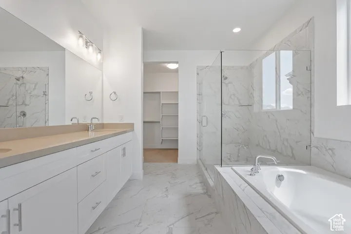 Full bathroom with double vanity, a marble finish shower, a garden tub, and marble finish floors