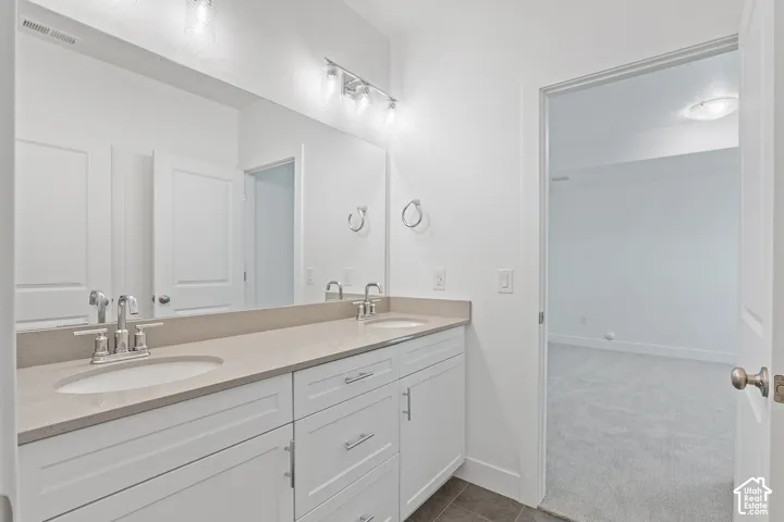 Bathroom with double vanity and tile patterned flooring