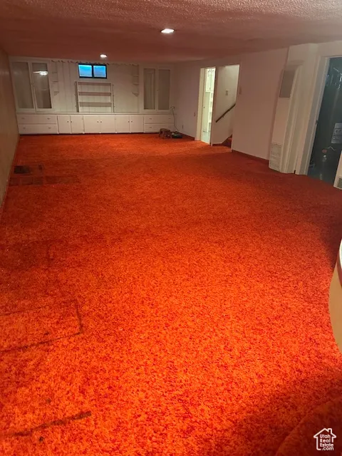 Empty room featuring a textured ceiling and a heating unit