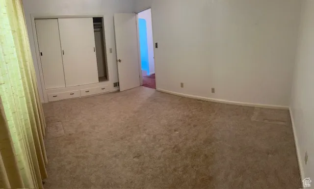 Unfurnished bedroom featuring carpet flooring and a closet