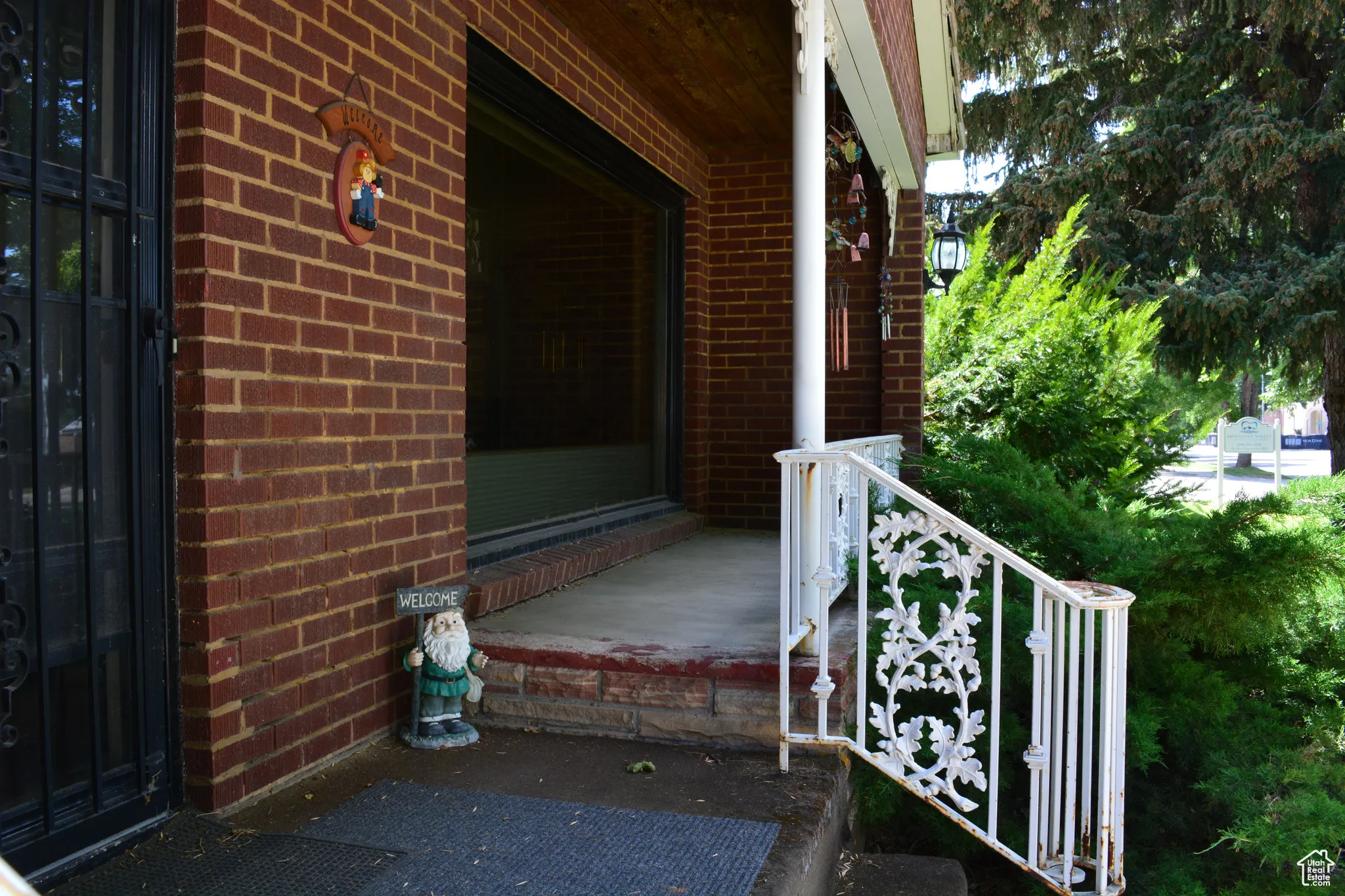 View of exterior entry featuring brick siding and covered porch