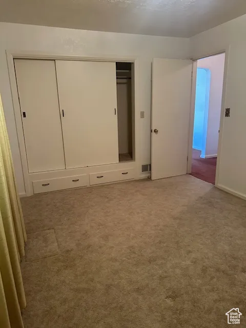 Unfurnished bedroom featuring carpet floors and a closet