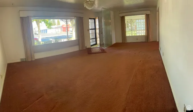 Empty room featuring carpet and plenty of natural light