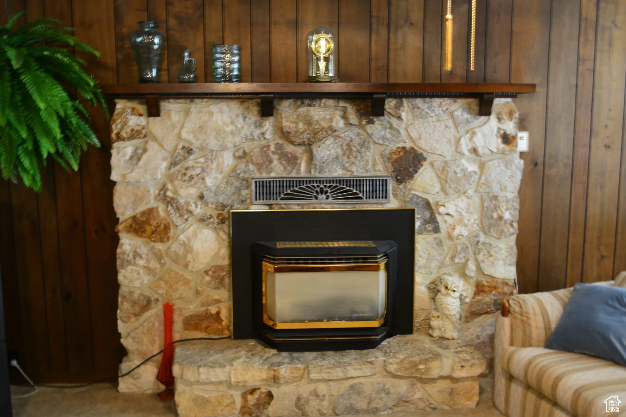 Detailed view of wood walls, carpet flooring, and a wood stove