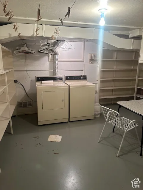 Finished basement featuring washer and dryer and a textured ceiling