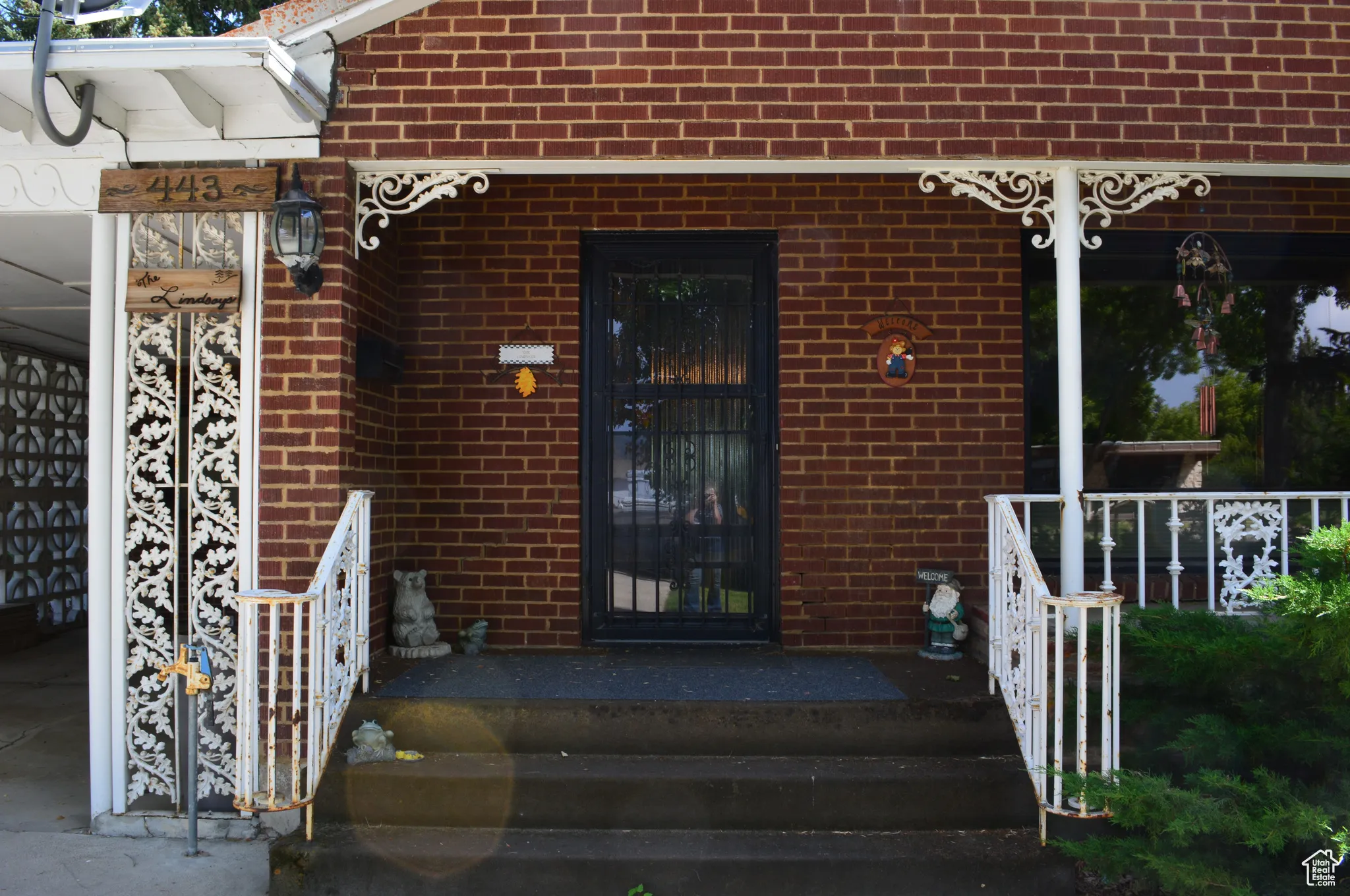 View of exterior entry with brick siding and a porch