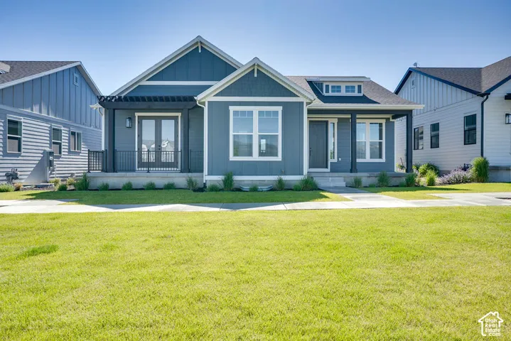 Contemporary ranch-style residence featuring a prominent front lawn