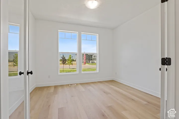 Unfurnished room featuring light wood-style flooring and baseboards