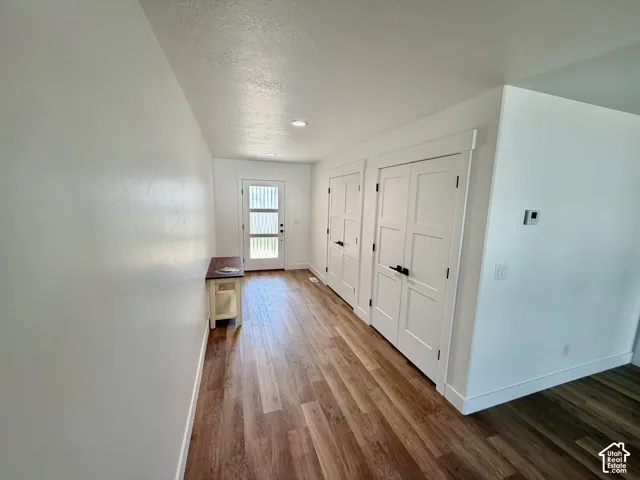 Entryway featuring wood-finish flooring, white walls, and a modern glass-panel front door