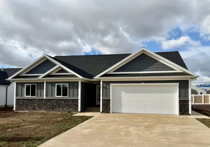 Craftsman inspired home with stone siding, a shingled roof, concrete driveway, and an attached garage