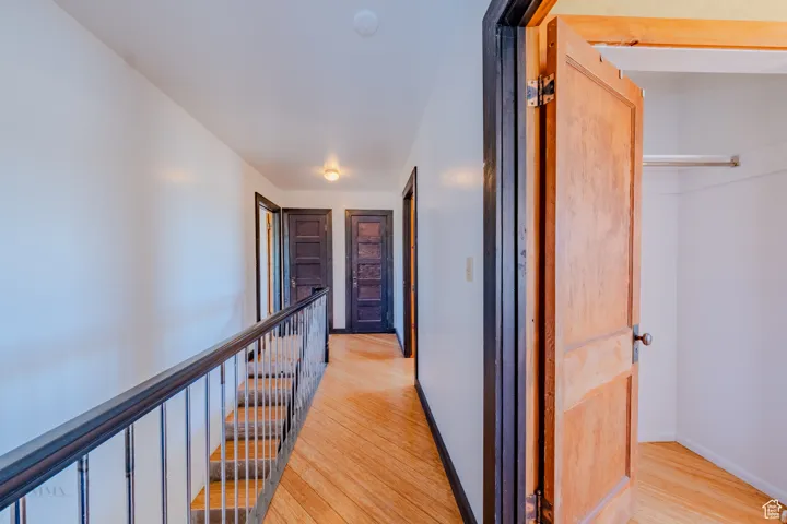 Corridor featuring light wood finished floors and an upstairs landing
