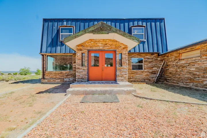 Doorway to property featuring stone siding and french doors