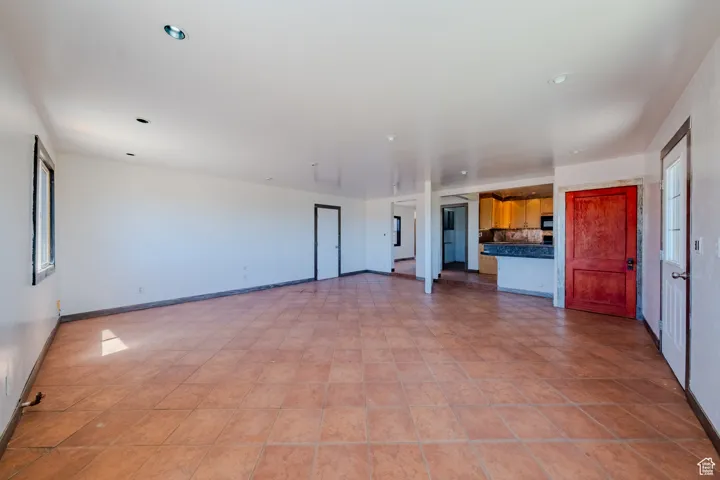 Unfurnished living room featuring baseboards