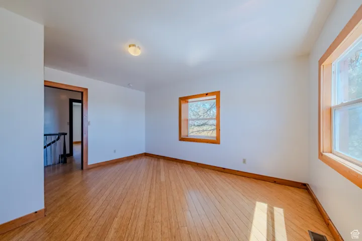 Empty room featuring baseboards and light wood finished floors