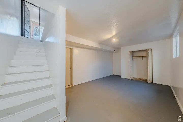 Basement featuring stairway and a textured ceiling
