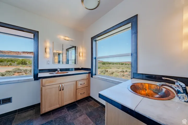 Bathroom with vanity and stone finish floors