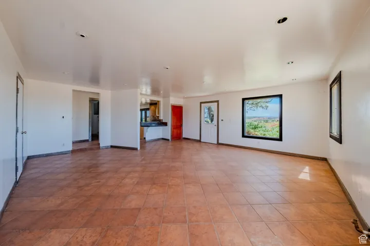 Unfurnished living room featuring baseboards and recessed lighting