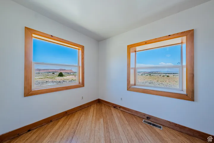 Spare room featuring wood-type flooring and baseboards