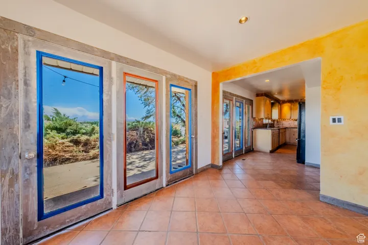 Doorway to outside with recessed lighting and light tile patterned flooring