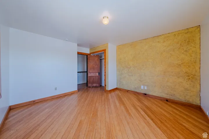 Unfurnished room with baseboards and wood finished floors