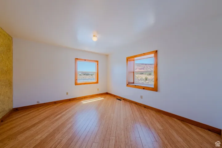 Unfurnished room with light wood-style floors and baseboards