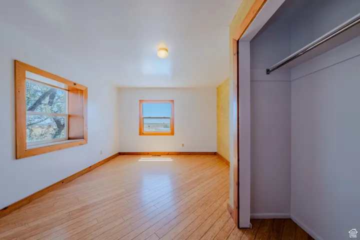 Unfurnished bedroom with wood finished floors and baseboards