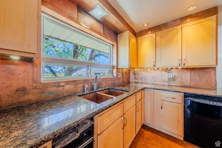 Kitchen featuring dishwasher and light brown cabinets