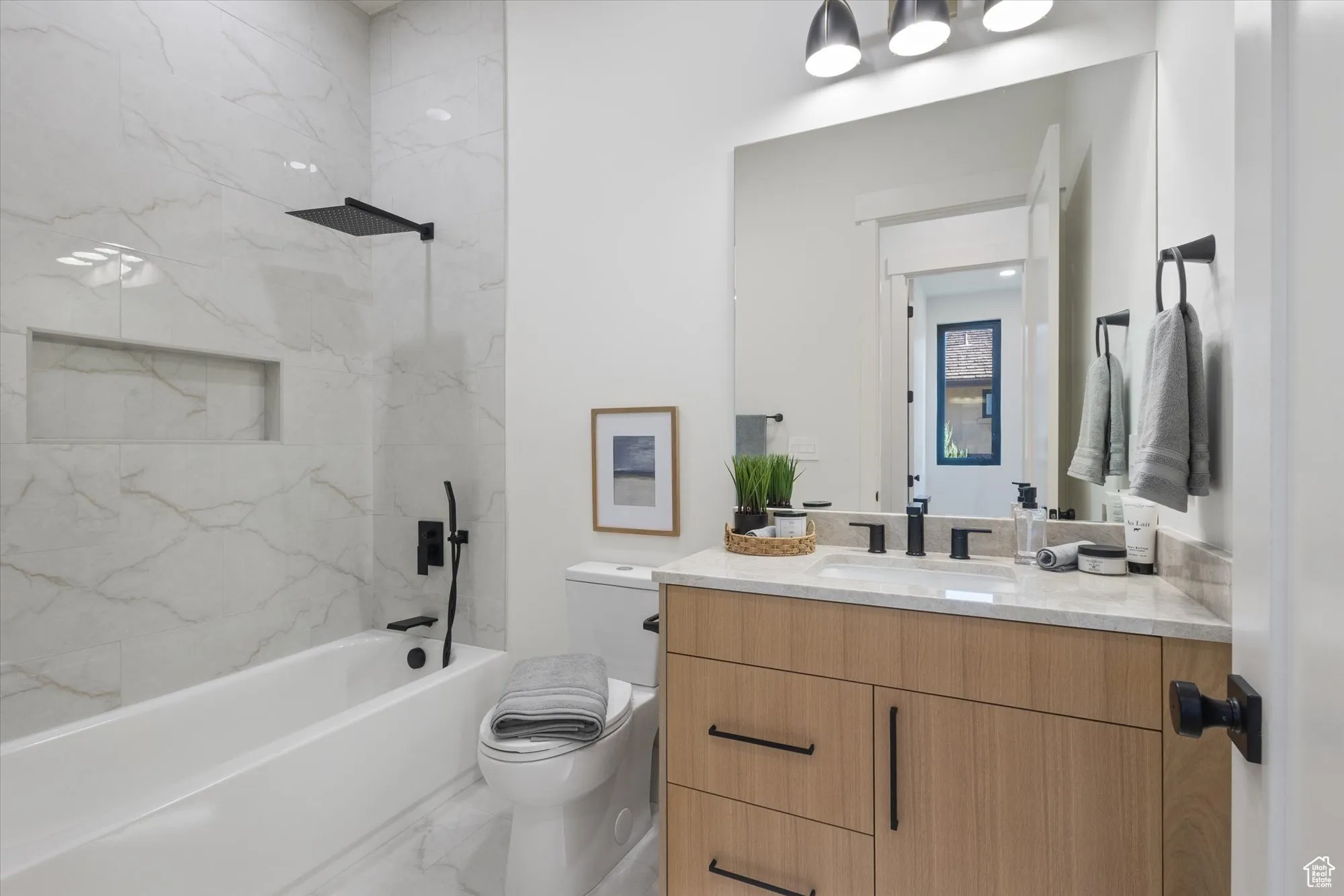 Bathroom featuring vanity, shower / bath combination, and marble finish flooring