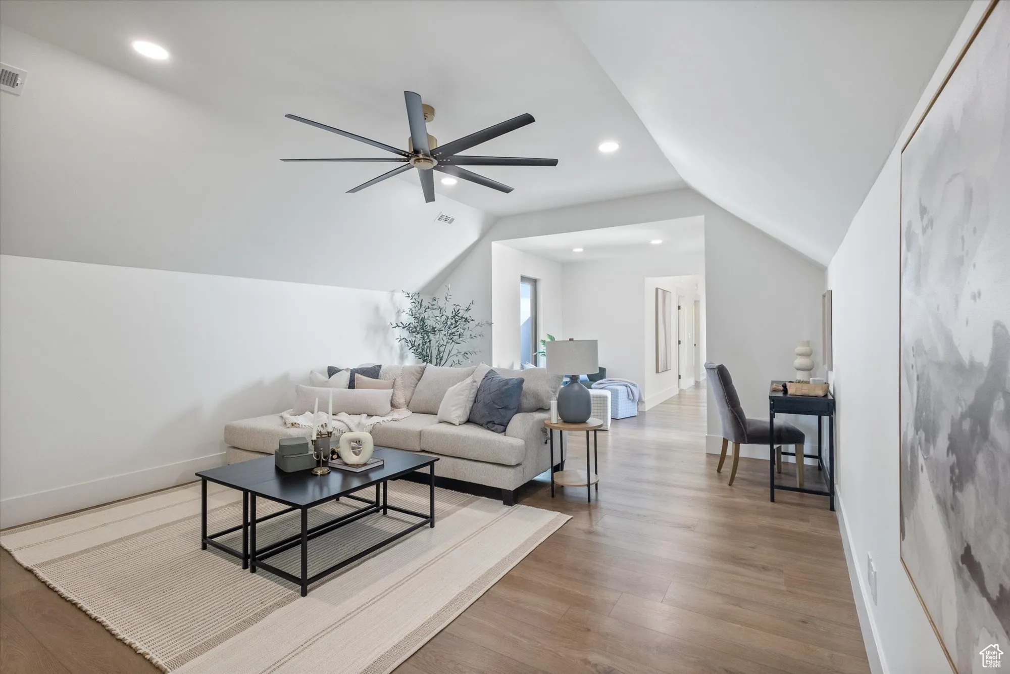 Living area featuring wood finished floors, lofted ceiling, a ceiling fan, and recessed lighting