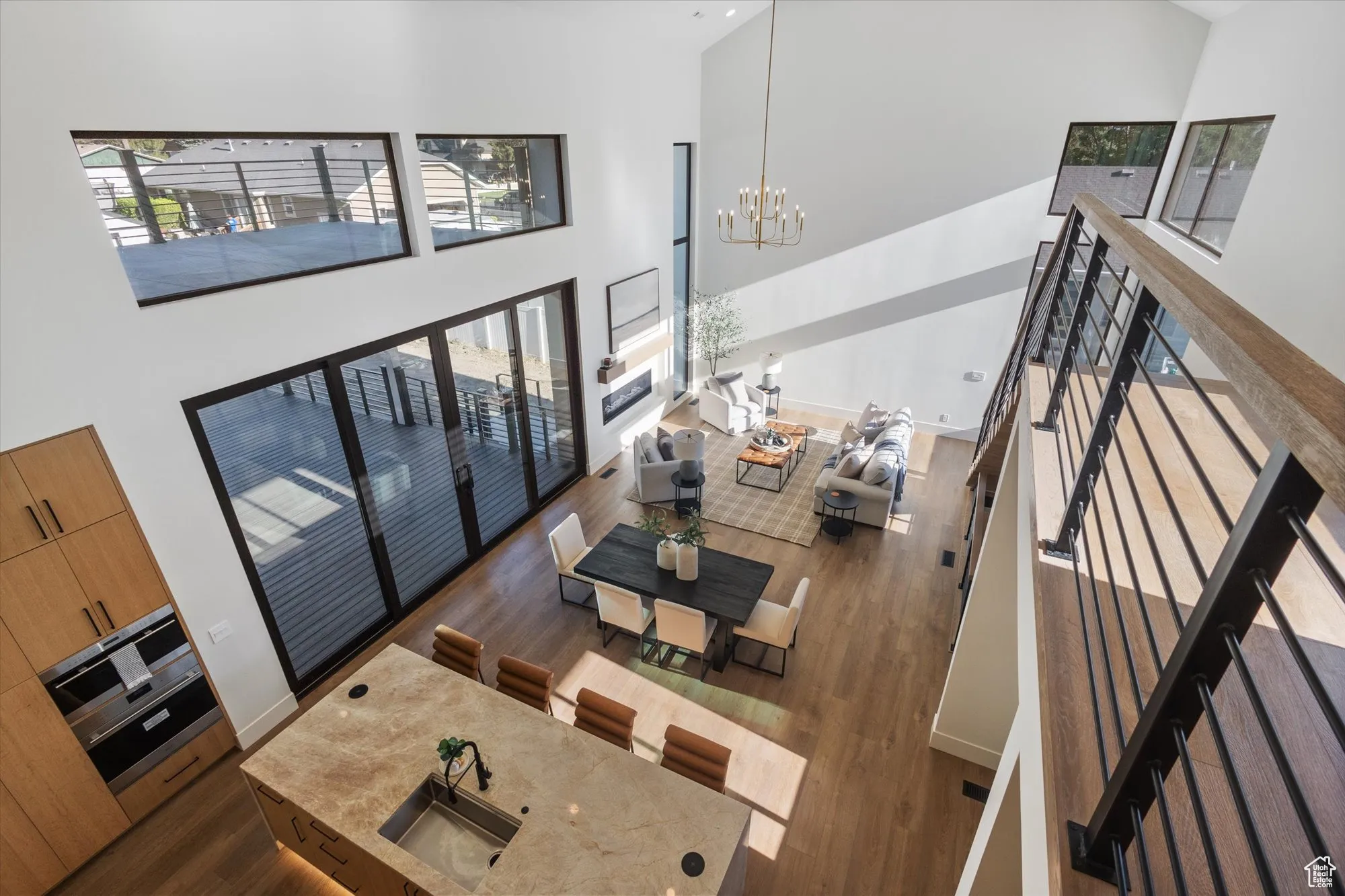 Living area with wood finished floors, a high ceiling, and a chandelier