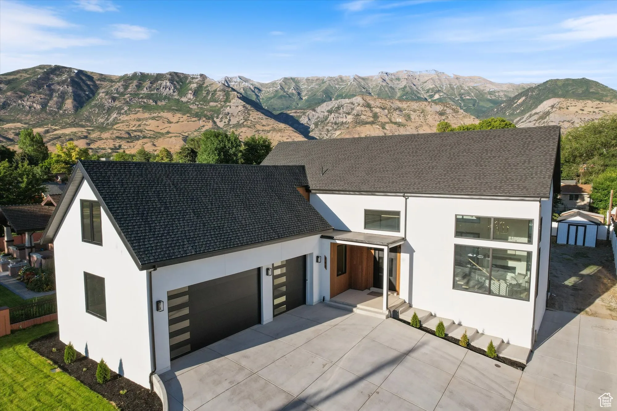 Modern home with stucco siding, a mountain view, driveway, and a garage