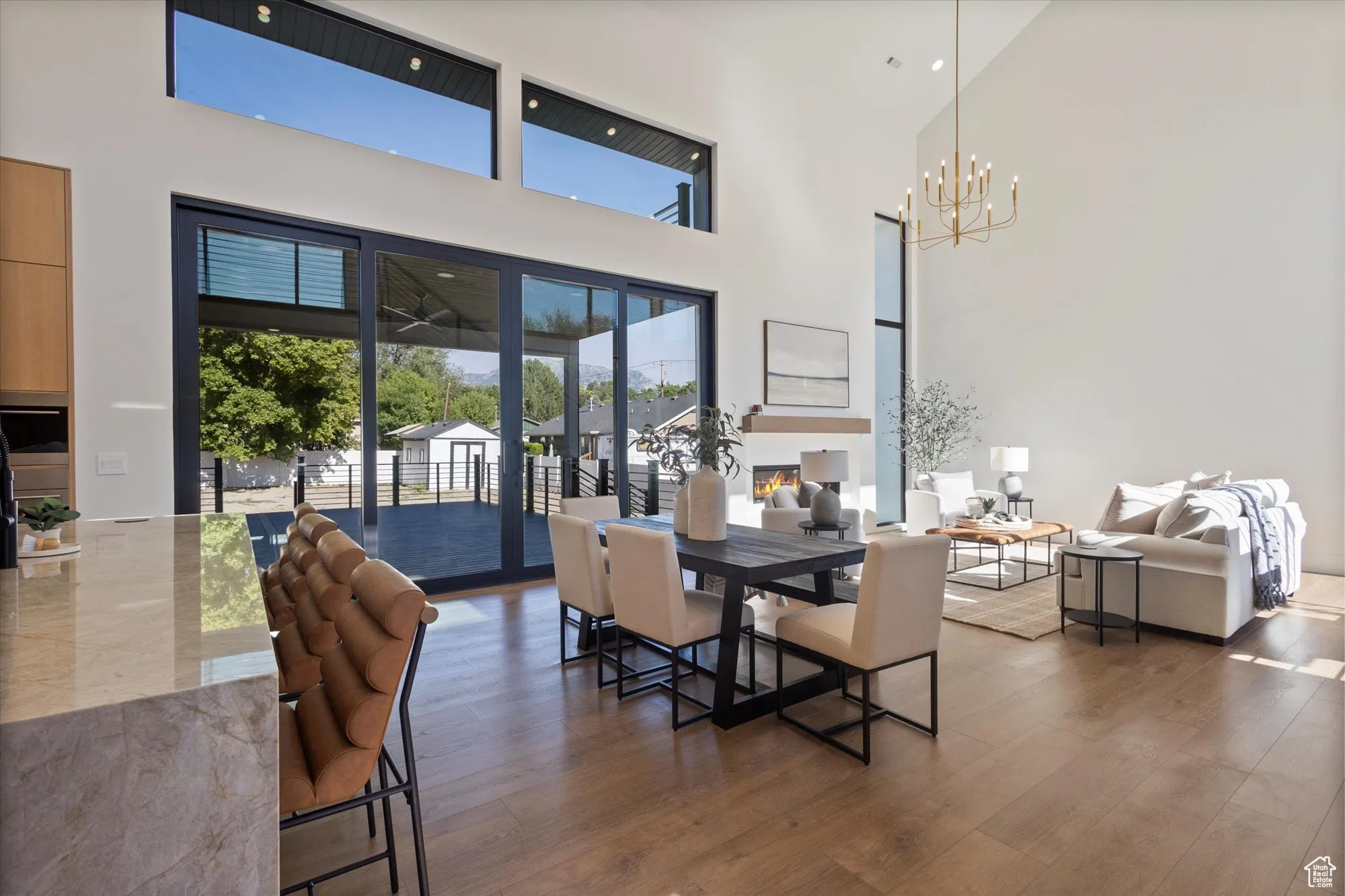 Dining area with plenty of natural light, wood finished floors, a chandelier, and a towering ceiling