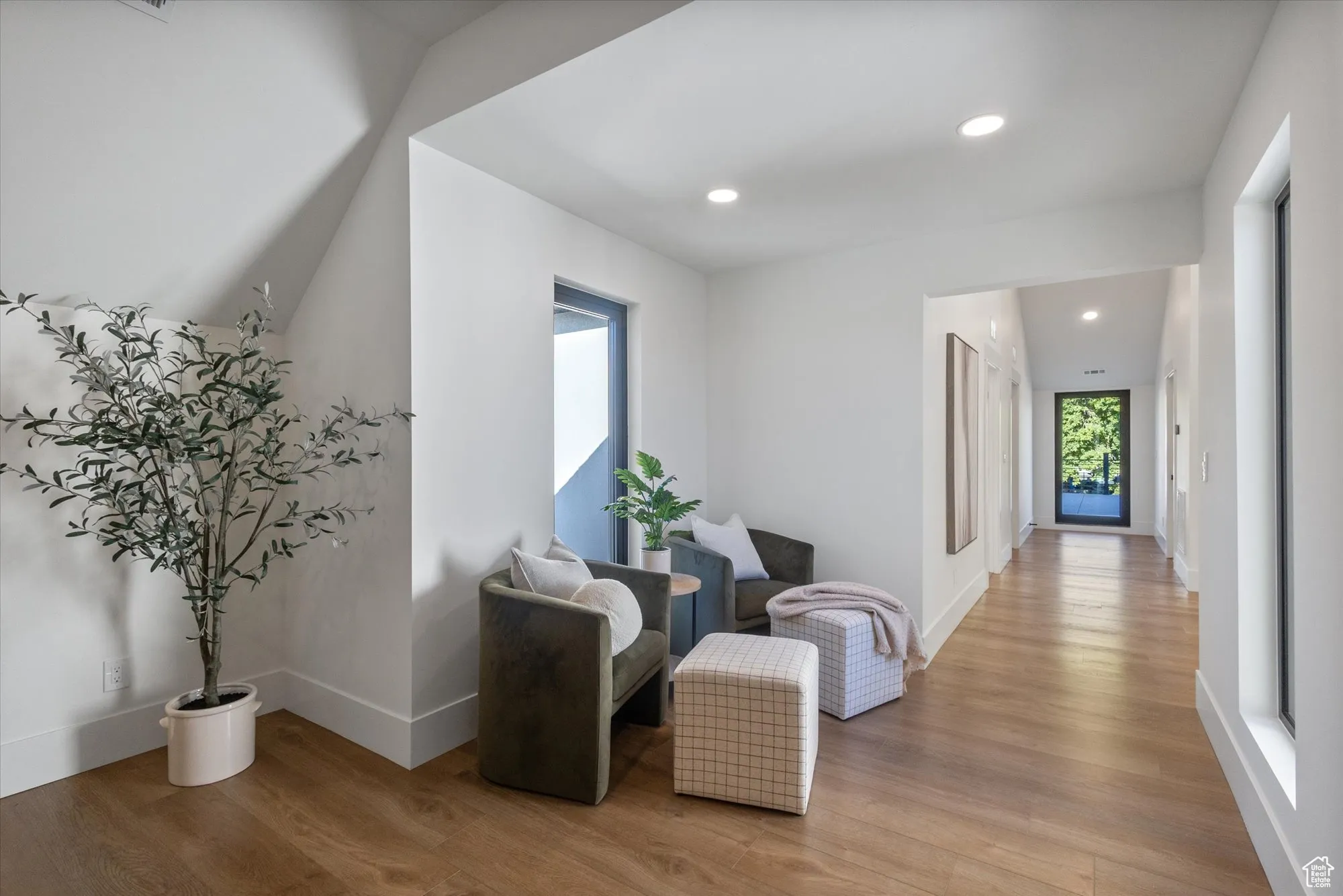 Living area with light wood-style flooring and recessed lighting