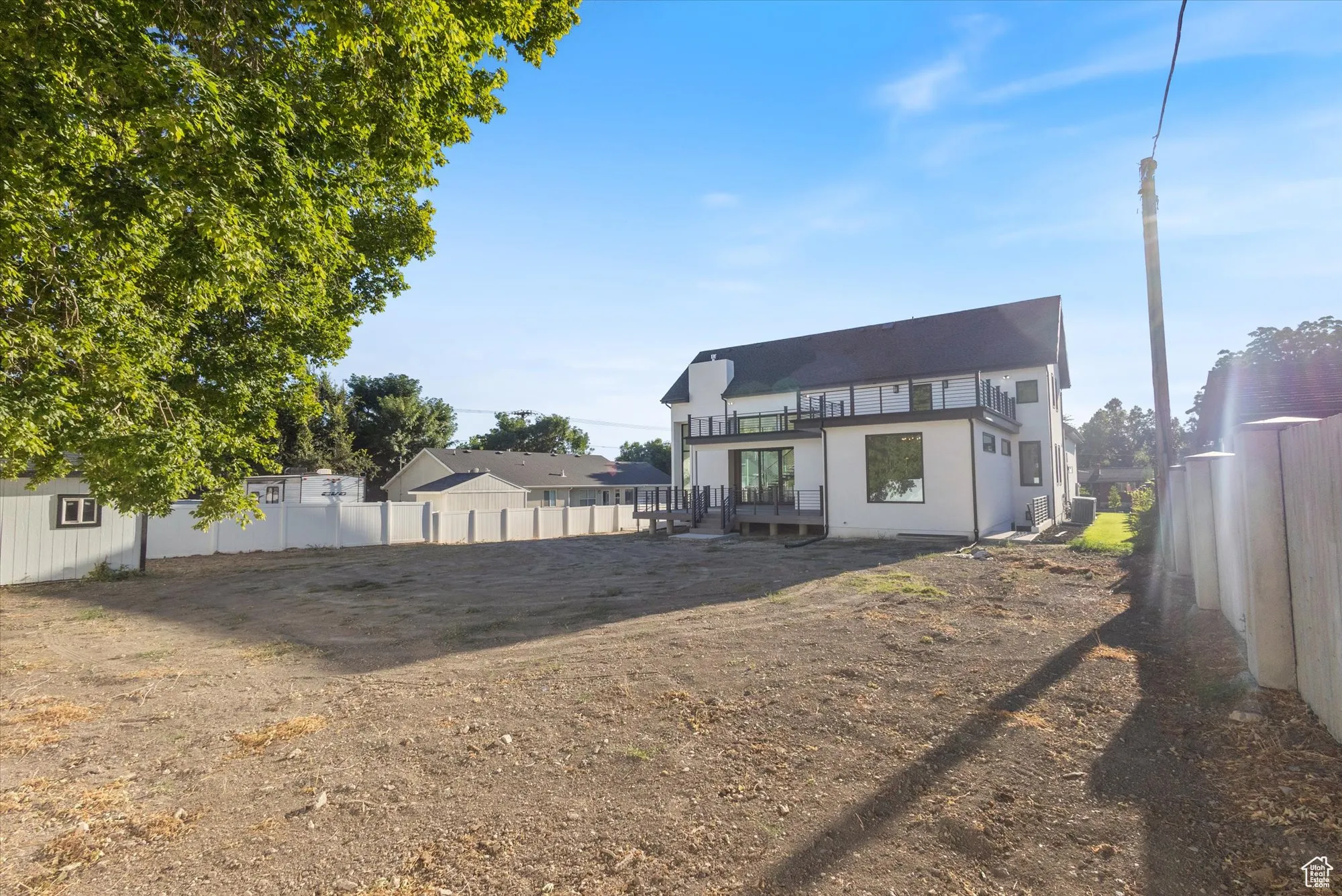 Back of property with a balcony and a fenced backyard