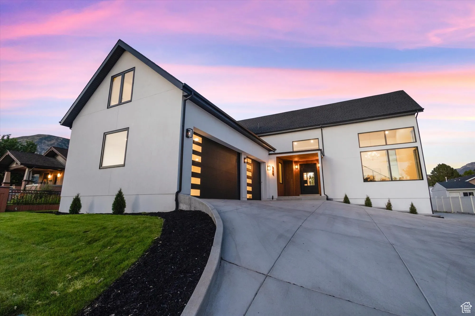 View of front of home featuring a garage, driveway, and stucco siding